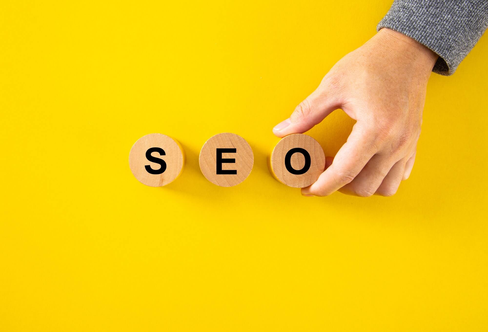 SEO (Search Engine Optimization) text wooden cube blocks on yellow